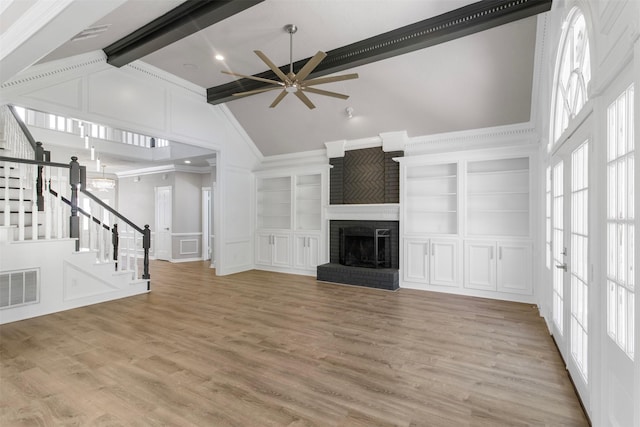 unfurnished living room featuring light wood-type flooring, ceiling fan, beam ceiling, high vaulted ceiling, and a fireplace