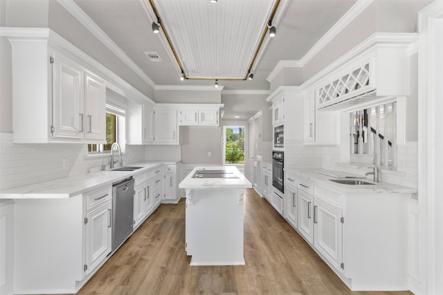 kitchen with appliances with stainless steel finishes, a center island, rail lighting, and white cabinetry