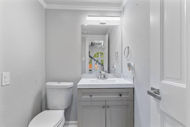 bathroom featuring vanity, toilet, and crown molding