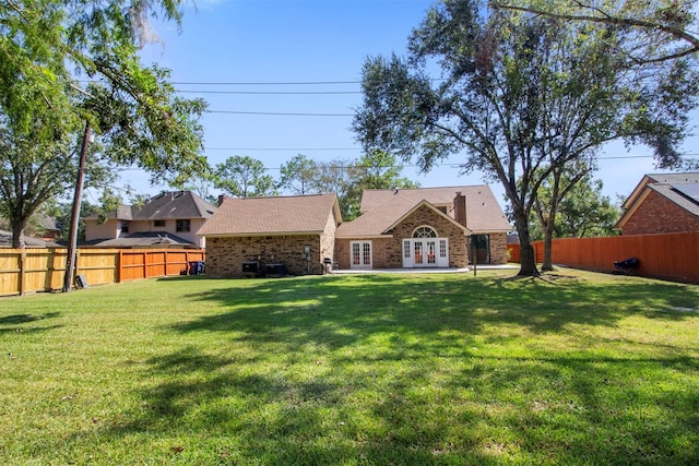 rear view of property featuring a yard and french doors