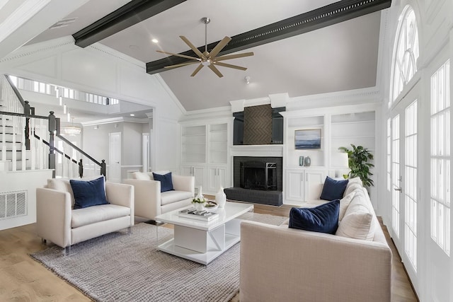 living room with a brick fireplace, ceiling fan, beam ceiling, hardwood / wood-style flooring, and high vaulted ceiling