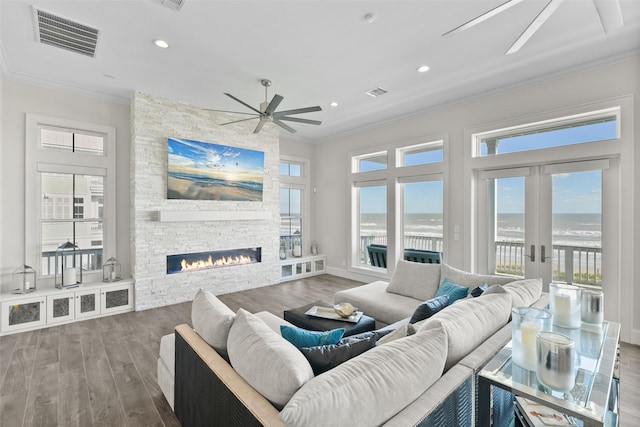 11707 Beachside, Galveston, TX 77554 - living area featuring ceiling fan, crown molding, wood finished floors, a stone fireplace, and recessed lighting