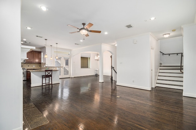 living room featuring dark hardwood / wood-style flooring, ornamental molding, and ceiling fan