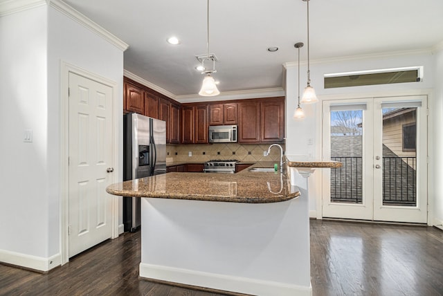 kitchen with backsplash, appliances with stainless steel finishes, dark hardwood / wood-style floors, hanging light fixtures, and sink