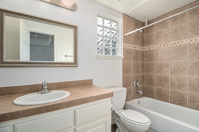 full bathroom with vanity, tiled shower / bath combo, and toilet