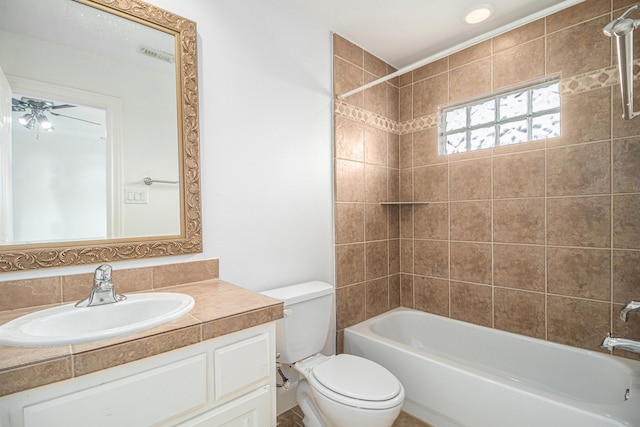 full bathroom featuring ceiling fan, vanity, toilet, and tiled shower / bath combo