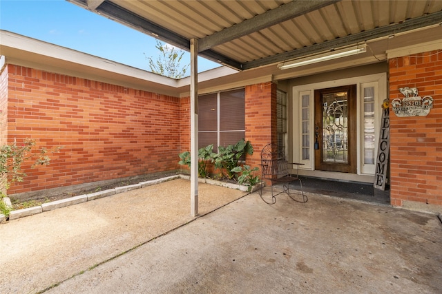 view of exterior entry featuring a patio area