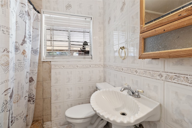 bathroom featuring toilet, tile walls, sink, and a shower with shower curtain