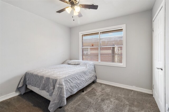 bedroom with a closet, ceiling fan, and dark carpet