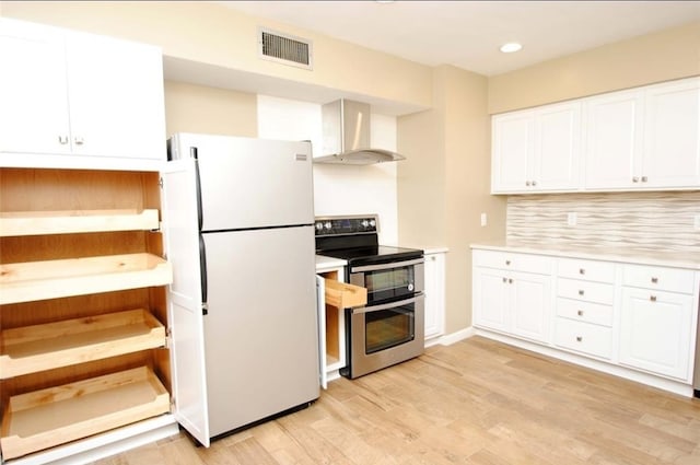 kitchen featuring light wood-type flooring, white cabinetry, wall chimney exhaust hood, stainless steel electric range oven, and white refrigerator