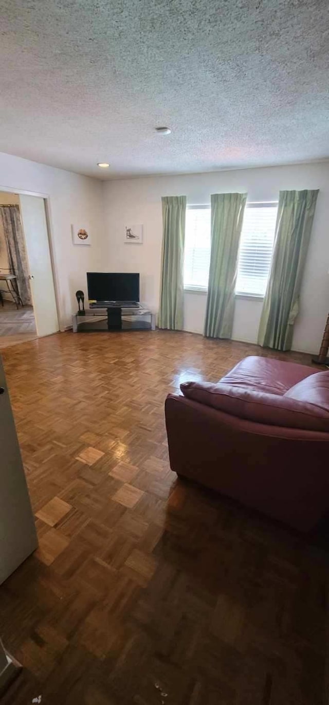 living room with parquet flooring and a textured ceiling