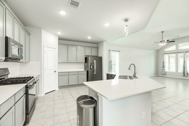 kitchen featuring stainless steel appliances, sink, plenty of natural light, and an island with sink