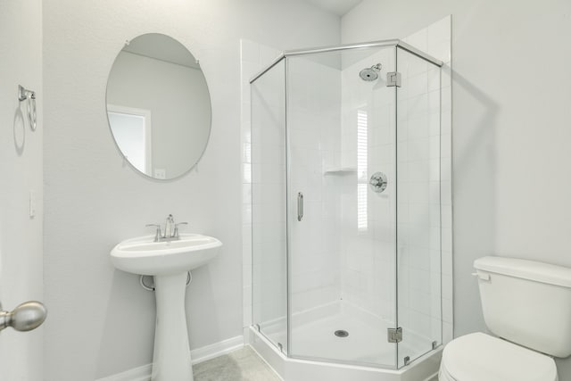 bathroom featuring toilet and an enclosed shower