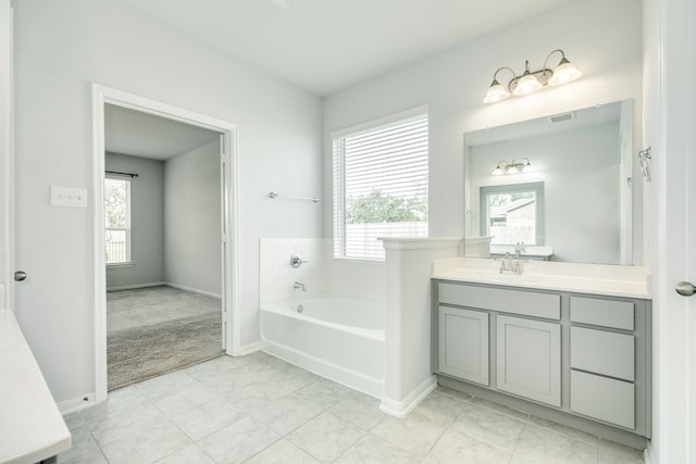 bathroom featuring vanity, a bathing tub, tile patterned floors, and a wealth of natural light