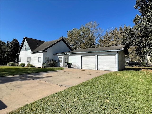 view of front of property featuring an attached garage, concrete driveway, and a front lawn