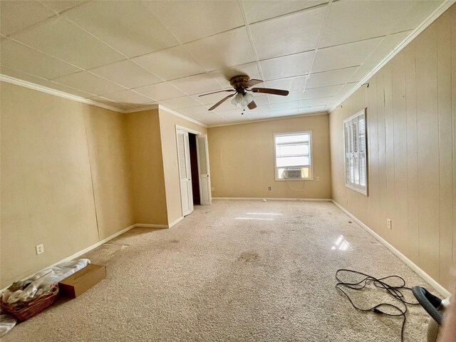 unfurnished room featuring ceiling fan, crown molding, carpet floors, baseboards, and cooling unit