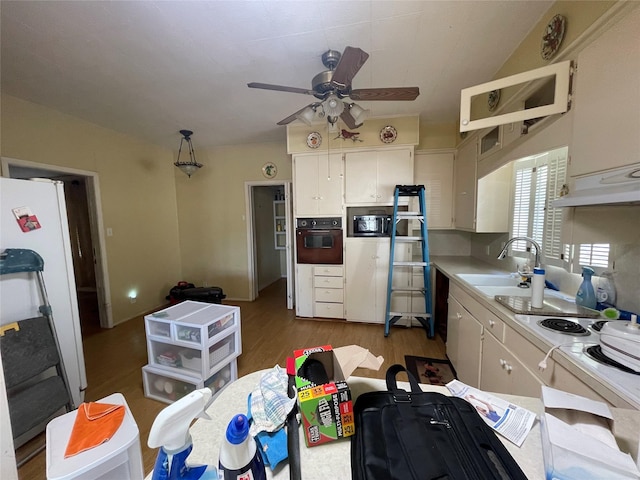 kitchen featuring white cabinets, ceiling fan, a sink, light countertops, and black oven