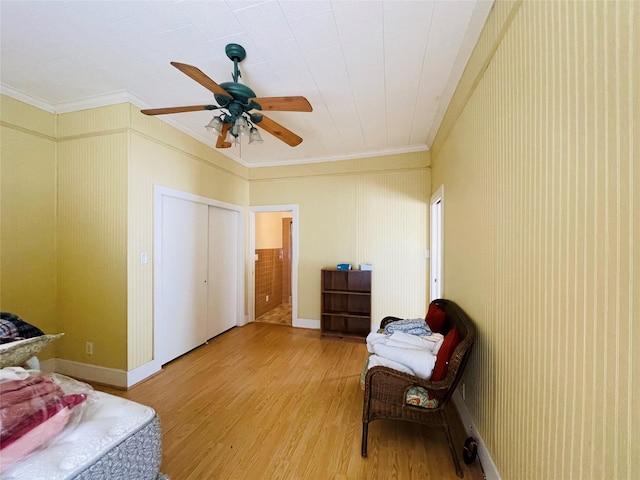 bedroom featuring ornamental molding, a ceiling fan, and light wood-style flooring