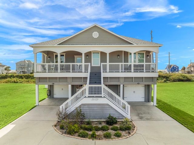 coastal inspired home with covered porch, a front yard, and a garage