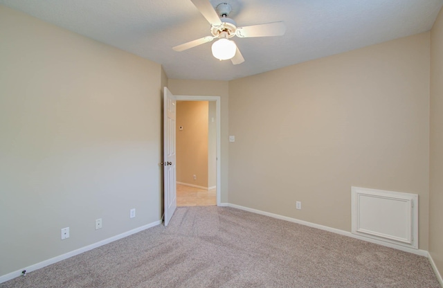 unfurnished room with a ceiling fan, light colored carpet, and baseboards