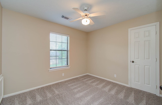 spare room featuring carpet flooring and ceiling fan