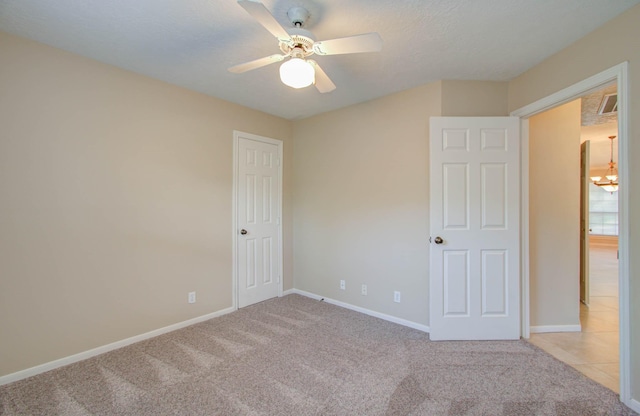 unfurnished bedroom with ceiling fan, baseboards, a textured ceiling, and light colored carpet