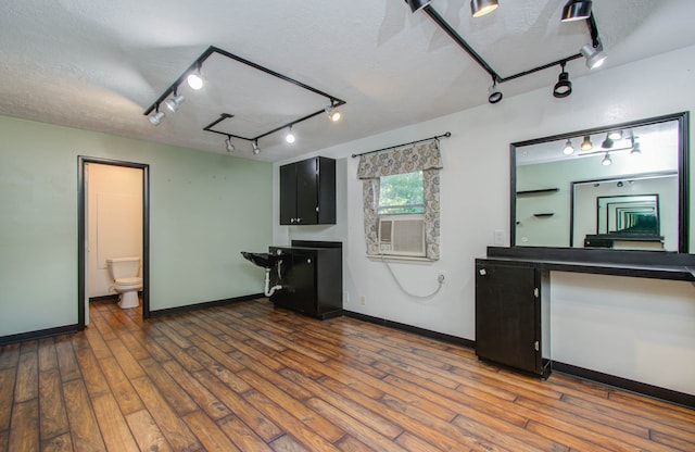 kitchen with dark hardwood / wood-style floors, a textured ceiling, and rail lighting