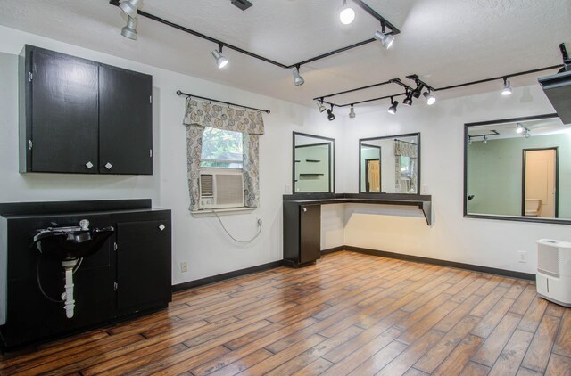 interior space featuring a textured ceiling, wood-type flooring, and rail lighting