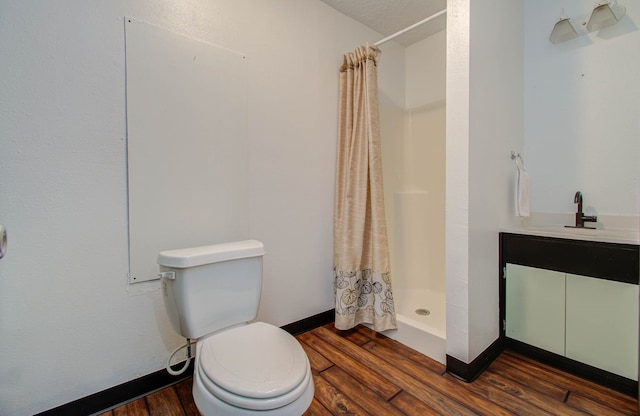 bathroom featuring toilet, curtained shower, hardwood / wood-style flooring, and vanity