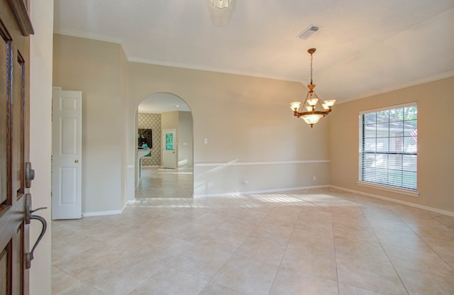 empty room featuring ornamental molding, light tile patterned floors, and a chandelier