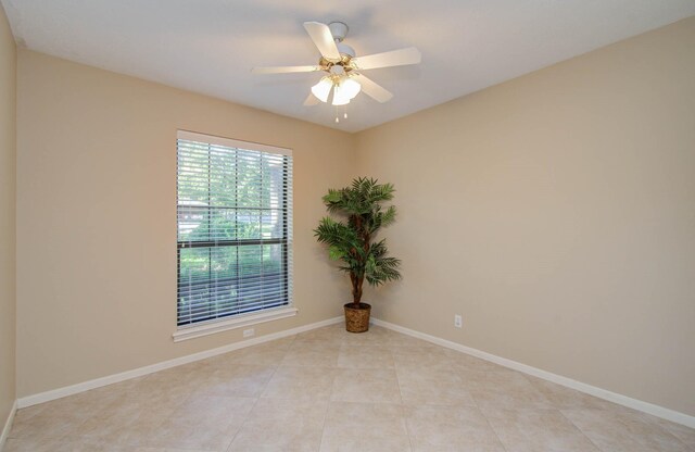 tiled spare room featuring ceiling fan