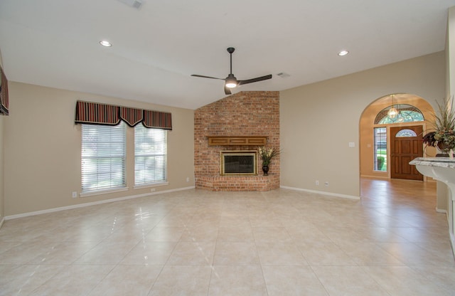 unfurnished living room featuring light tile patterned floors, ceiling fan, lofted ceiling, and a fireplace