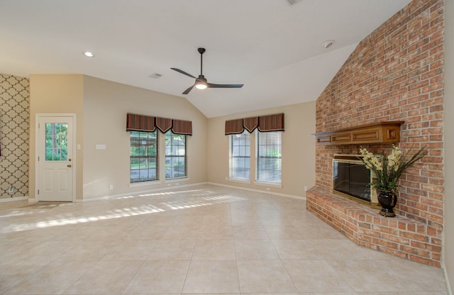 unfurnished living room with ceiling fan, light tile patterned floors, a fireplace, and vaulted ceiling