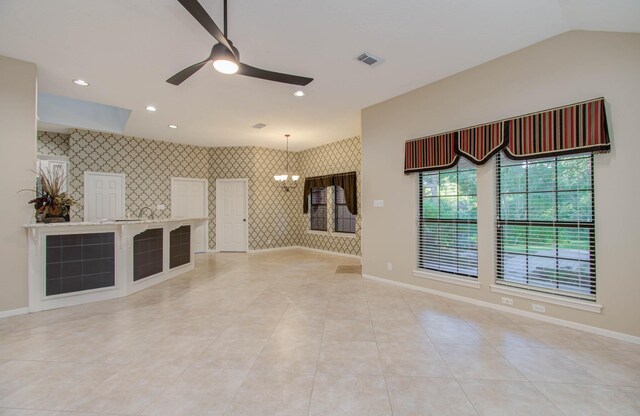 unfurnished living room featuring ceiling fan with notable chandelier and light tile patterned floors