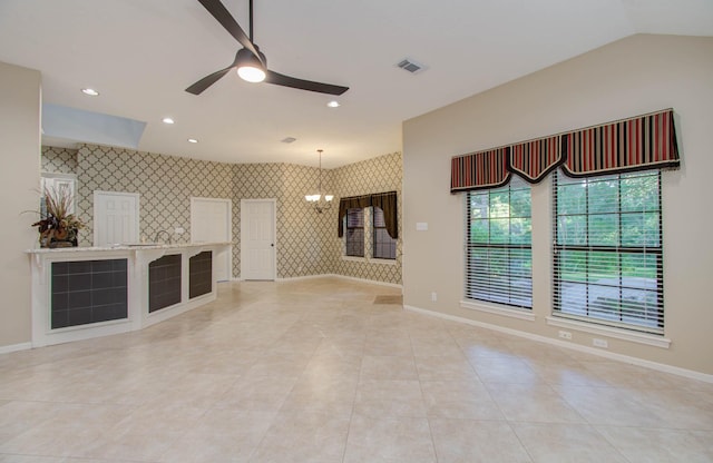 unfurnished living room featuring baseboards, visible vents, and wallpapered walls