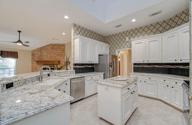 kitchen with visible vents, appliances with stainless steel finishes, a center island, a peninsula, and a sink