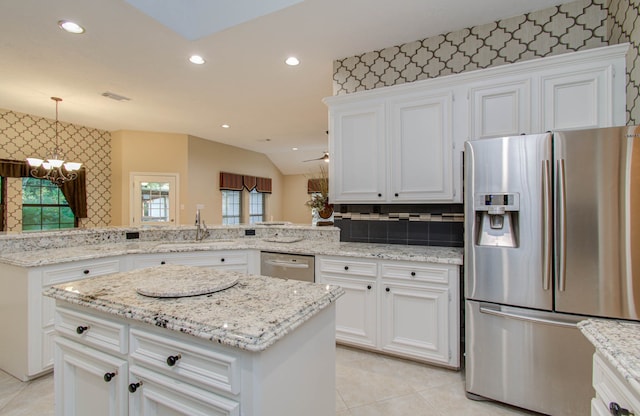 kitchen featuring kitchen peninsula, tasteful backsplash, appliances with stainless steel finishes, white cabinetry, and sink