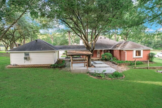 rear view of property featuring cooling unit and a lawn