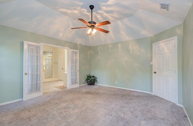 empty room featuring french doors, lofted ceiling, light colored carpet, visible vents, and baseboards