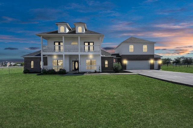 view of front of property featuring a balcony, a garage, a yard, and covered porch