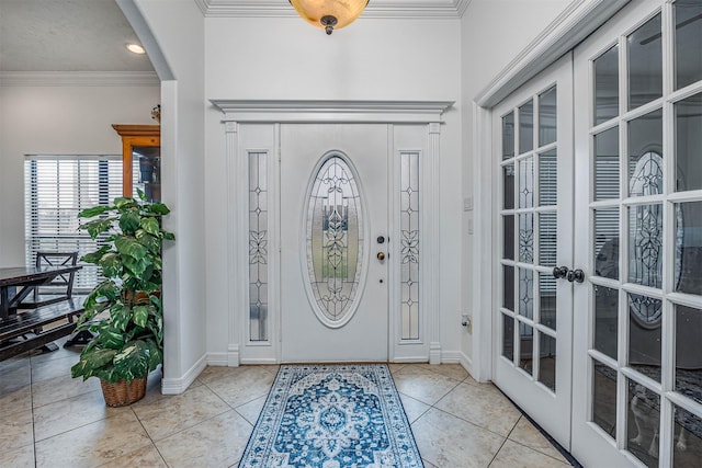 entryway with ornamental molding, french doors, and light tile patterned flooring