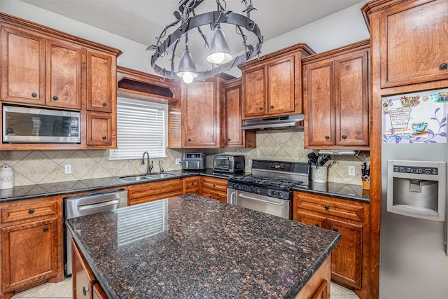 kitchen with pendant lighting, appliances with stainless steel finishes, sink, and tasteful backsplash