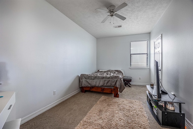 carpeted bedroom featuring a textured ceiling and ceiling fan