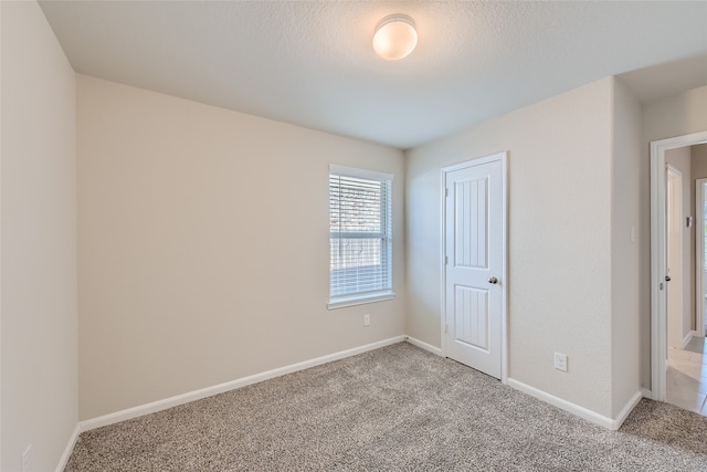 unfurnished bedroom featuring a textured ceiling, carpet floors, and a closet