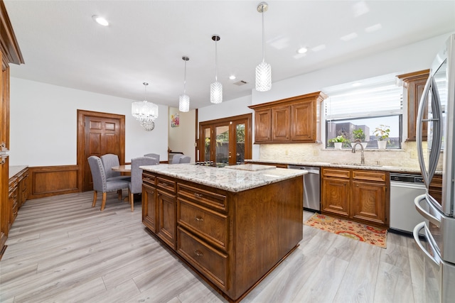 kitchen featuring a wealth of natural light, pendant lighting, a center island, and stainless steel appliances