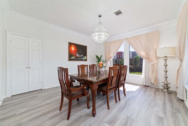 dining area with ornamental molding, a notable chandelier, and light hardwood / wood-style floors