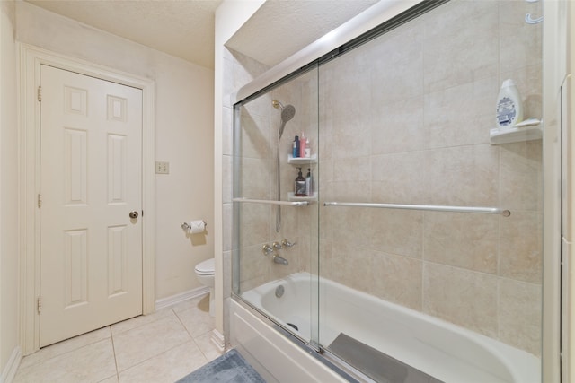 bathroom featuring tile patterned floors, enclosed tub / shower combo, a textured ceiling, and toilet