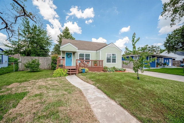 view of front of home with a wooden deck, a front lawn, and a garage