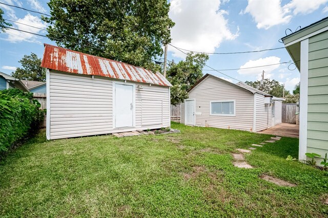 view of yard with fence, an outdoor structure, and a storage shed