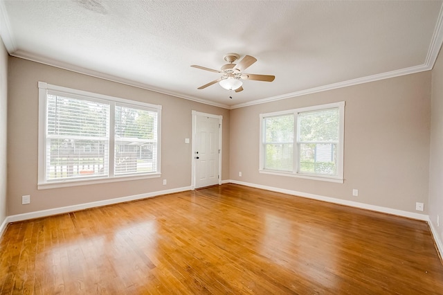 unfurnished room featuring baseboards, crown molding, and plenty of natural light